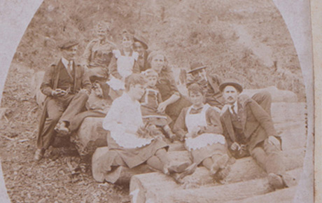 Grup de muncitori forestieri, cu familiile, în pădurile de la Moneasa, mai 1918. Fotografie sepia, 11 x 8,5 cm; 20 x 16 cm. Pe fotografie, se află consemnarea: ”1918, V/Emlék”. Transfer, p.v. nr. 270/10.02.1984.